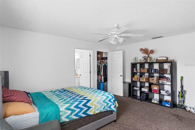 bedroom featuring ensuite bath, a textured ceiling, ceiling fan, carpet floors, and a closet