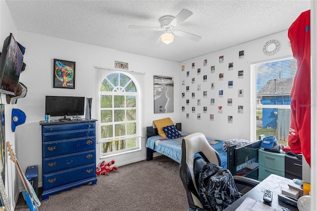 carpeted bedroom featuring ceiling fan and a textured ceiling