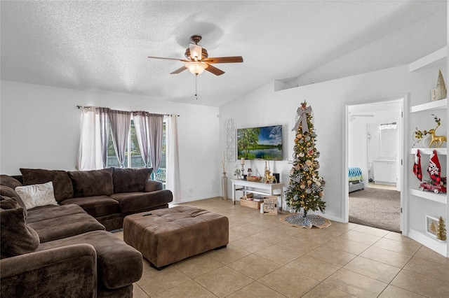 living room with ceiling fan, light tile patterned flooring, and vaulted ceiling