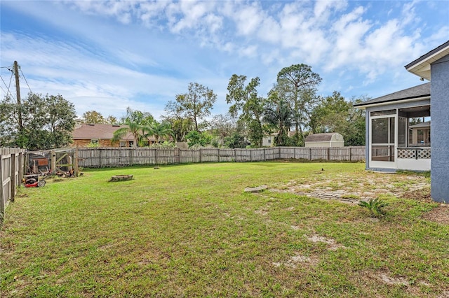 view of yard featuring a sunroom and a fire pit