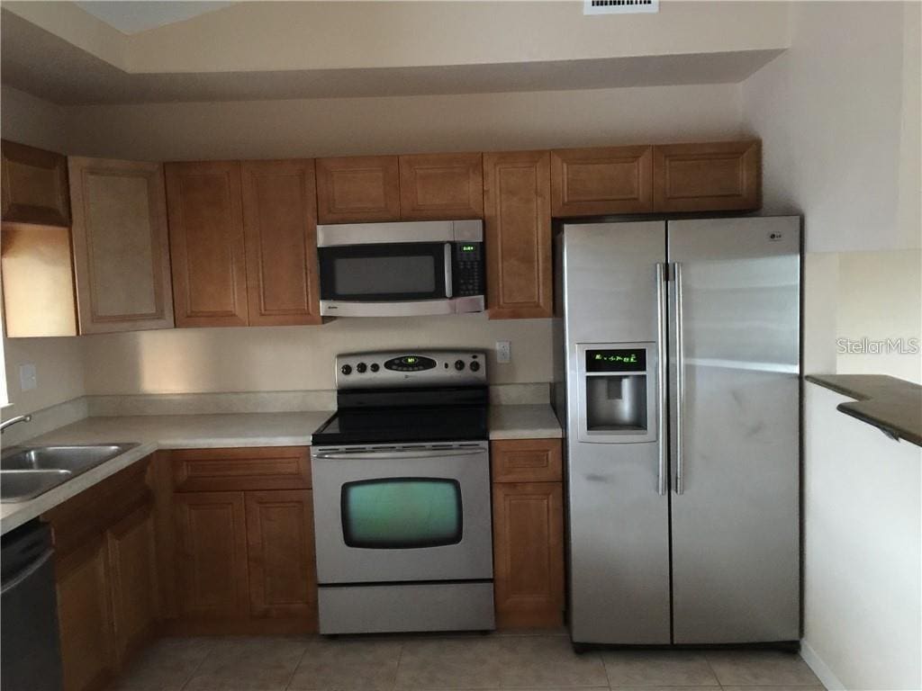 kitchen with sink, light tile patterned floors, and stainless steel appliances