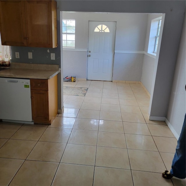 566/568 Imperial Pl, Kissimmee, FL 34758 - kitchen featuring white dishwasher, brown cabinets, light tile patterned flooring, and baseboards