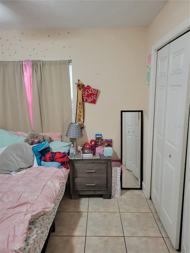 566/568 Imperial Pl, Kissimmee, FL 34758 - bedroom with light tile patterned flooring, a textured ceiling, and a closet