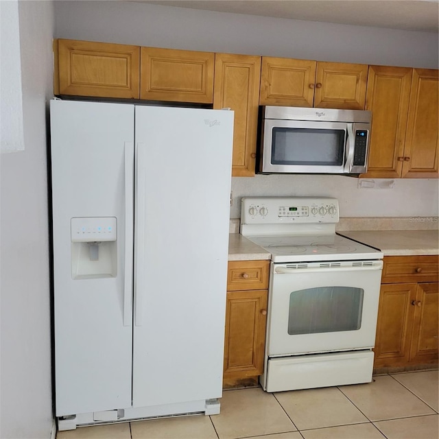 566/568 Imperial Pl, Kissimmee, FL 34758 - kitchen with white appliances, light tile patterned flooring, light countertops, and brown cabinets