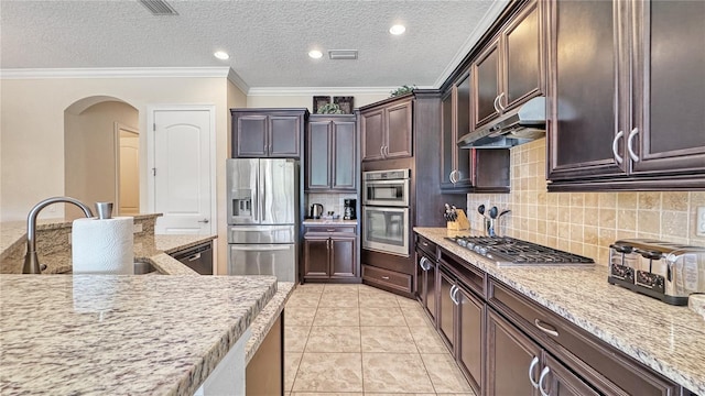 kitchen with exhaust hood, sink, light stone countertops, tasteful backsplash, and stainless steel appliances