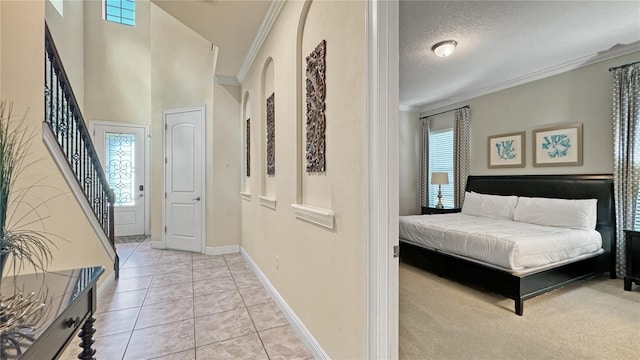 bedroom featuring crown molding, light tile patterned floors, and a textured ceiling