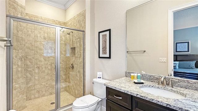 bathroom with crown molding, vanity, a shower with shower door, and toilet