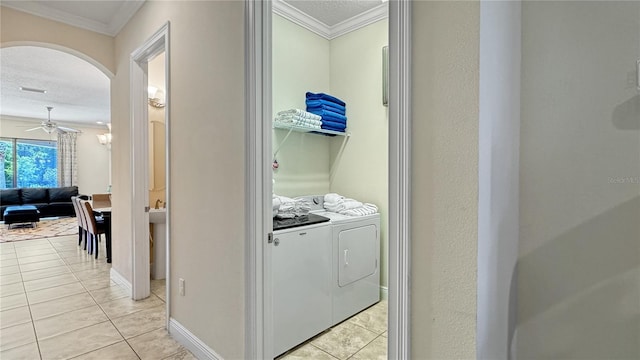 laundry area featuring ceiling fan, washing machine and dryer, a textured ceiling, light tile patterned floors, and ornamental molding