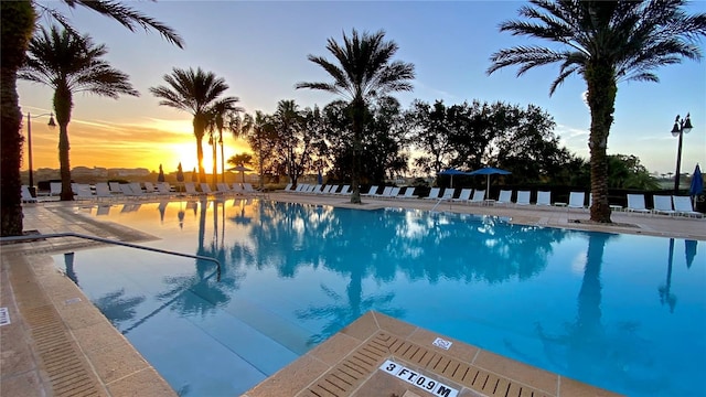 pool at dusk featuring a patio area