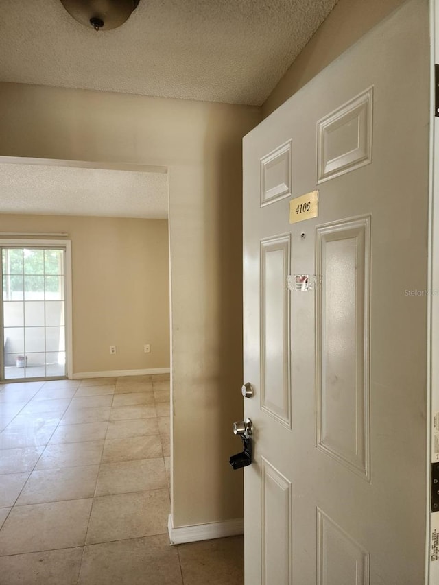 interior space with light tile patterned flooring and a textured ceiling