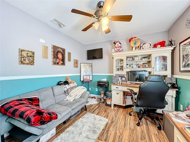 home office with light wood-type flooring and ceiling fan