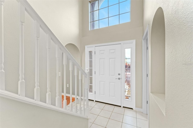 tiled foyer entrance with plenty of natural light and a high ceiling