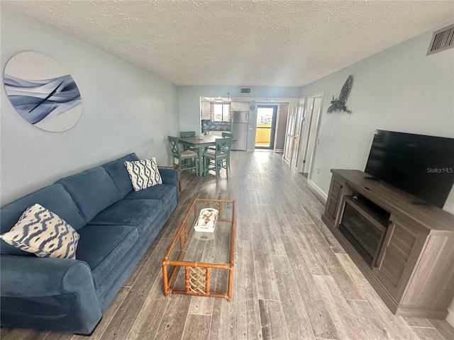 living room with hardwood / wood-style floors and a textured ceiling