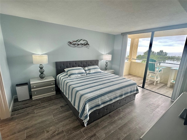 bedroom featuring dark hardwood / wood-style flooring and a textured ceiling