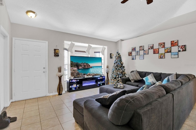 living room featuring ceiling fan, light tile patterned floors, and a textured ceiling