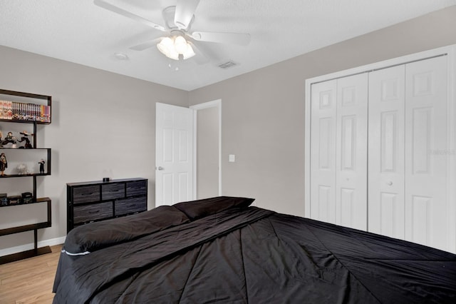 bedroom with ceiling fan, a closet, and light hardwood / wood-style flooring