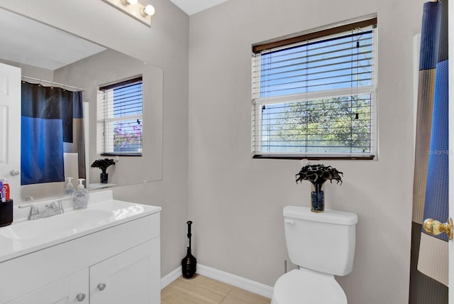 bathroom with vanity, a healthy amount of sunlight, and toilet