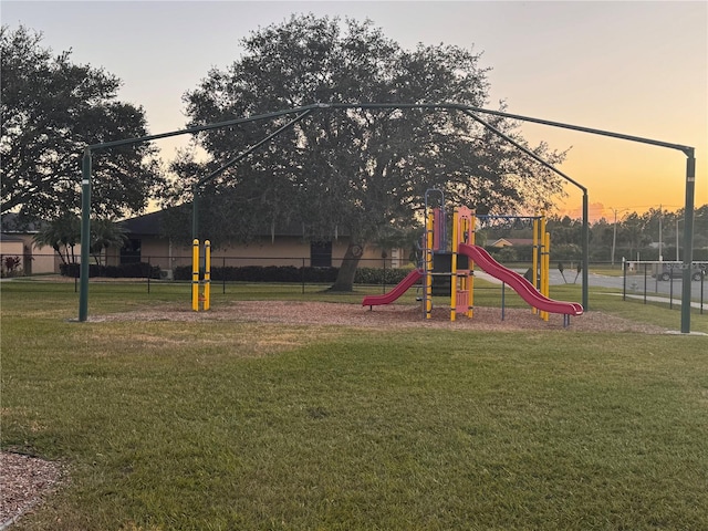 playground at dusk featuring a yard