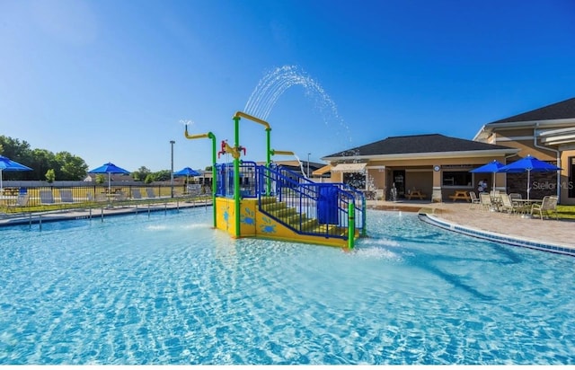 view of pool with a playground, a patio area, and pool water feature