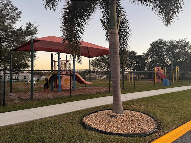 playground at dusk featuring a yard