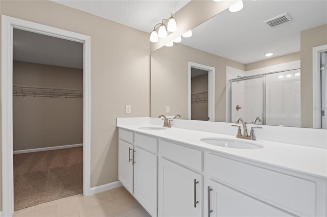 bathroom with tile patterned floors, vanity, and a shower with shower door