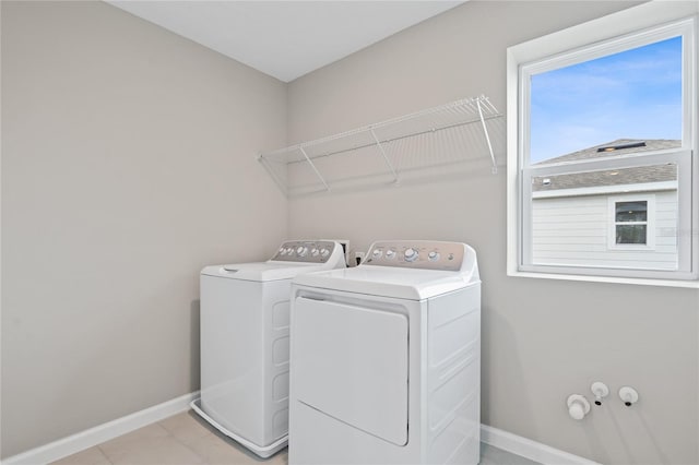 washroom with washing machine and dryer and light tile patterned floors