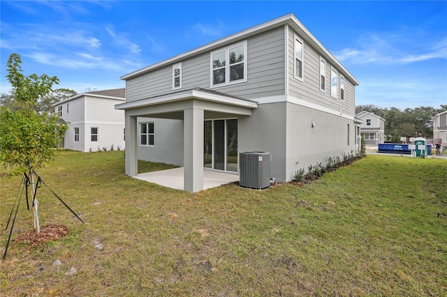 rear view of house featuring central air condition unit, a patio area, and a yard