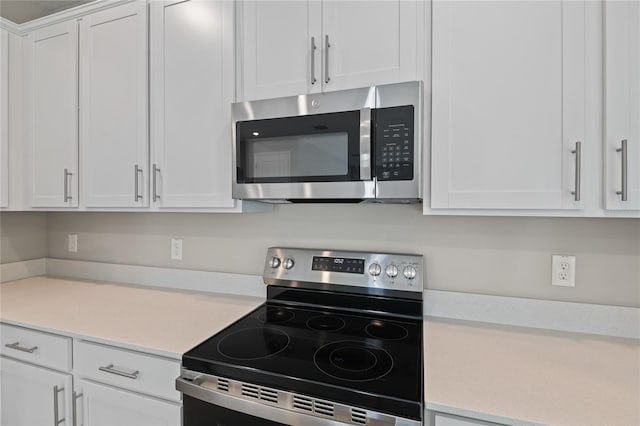 kitchen with white cabinetry and appliances with stainless steel finishes