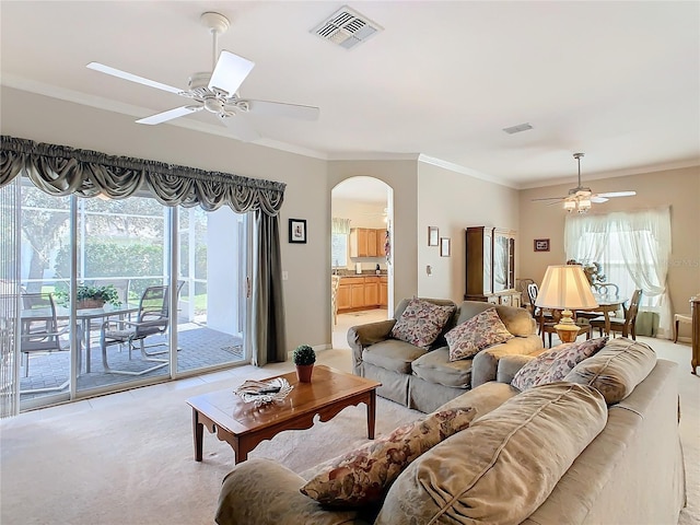 living room featuring crown molding, ceiling fan, and light colored carpet