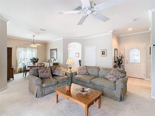 carpeted living room with ceiling fan and ornamental molding