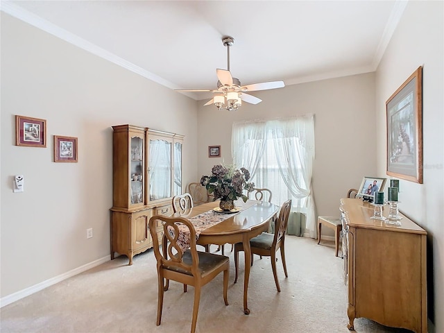 carpeted dining space with ceiling fan and ornamental molding