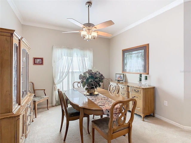 dining space with light colored carpet, ceiling fan, and crown molding