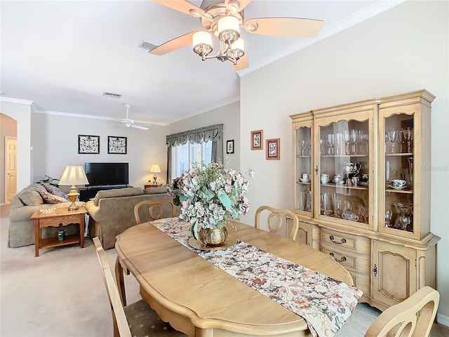 dining area featuring carpet flooring, crown molding, and ceiling fan