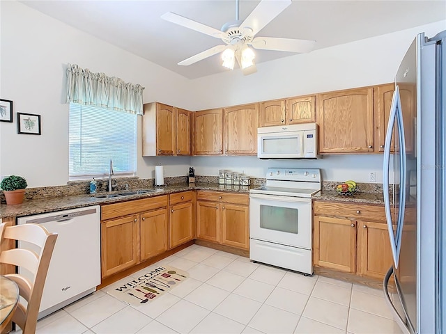 kitchen featuring ceiling fan, sink, dark stone counters, and white appliances