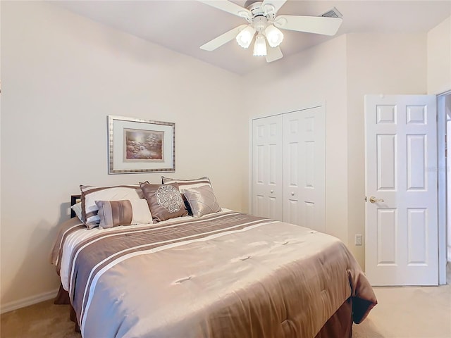 bedroom with ceiling fan, light colored carpet, and a closet