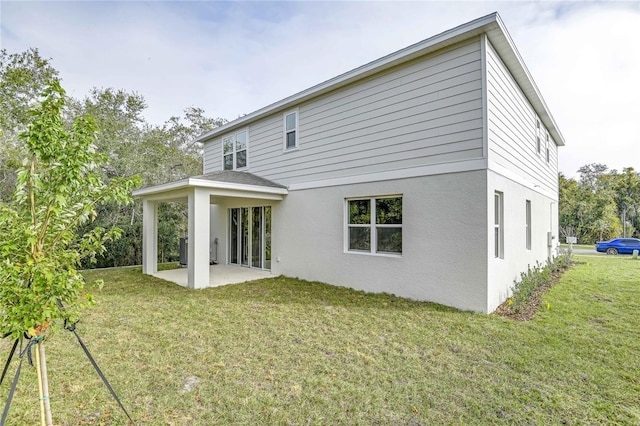 rear view of property featuring a lawn and a patio area