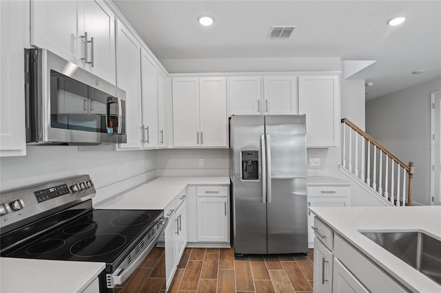 kitchen with white cabinets and appliances with stainless steel finishes