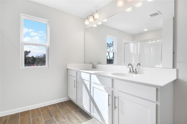 bathroom with vanity, a healthy amount of sunlight, and an enclosed shower