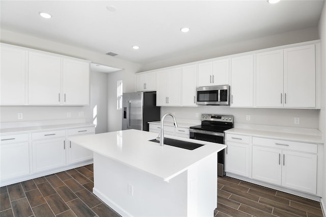 kitchen with sink, a center island with sink, white cabinets, and appliances with stainless steel finishes