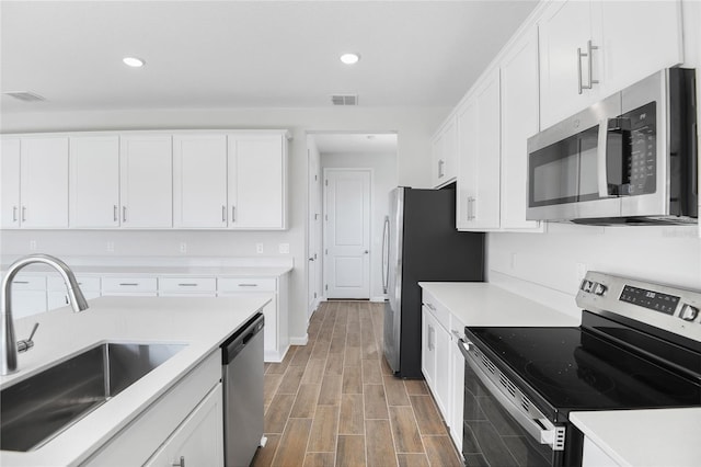 kitchen with stainless steel appliances, sink, and white cabinets