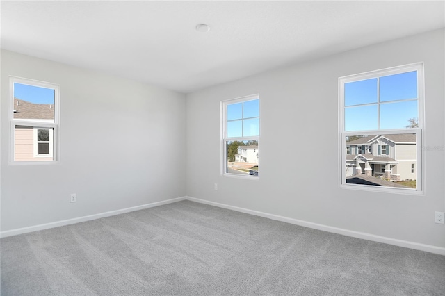 carpeted spare room featuring plenty of natural light