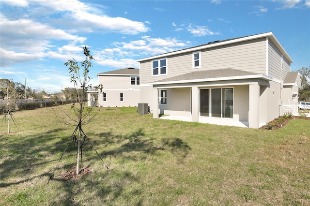 rear view of house with a yard and central AC