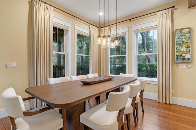 dining space featuring hardwood / wood-style floors and a notable chandelier