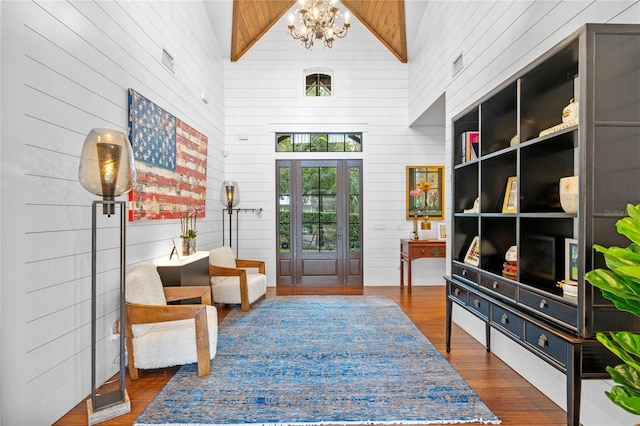 mudroom featuring beam ceiling, high vaulted ceiling, a chandelier, dark hardwood / wood-style floors, and wood walls