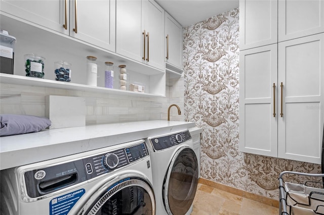 laundry area with washer and dryer and cabinets