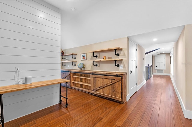 interior space with hardwood / wood-style flooring and lofted ceiling