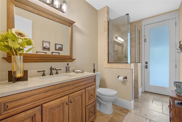 bathroom with a shower with door, vanity, and toilet