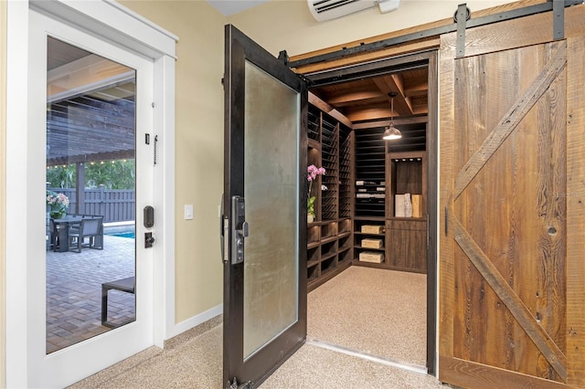 wine area featuring beamed ceiling, a barn door, and a wall mounted air conditioner