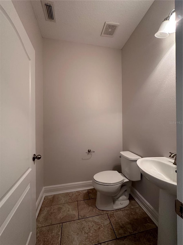 bathroom featuring a textured ceiling and toilet