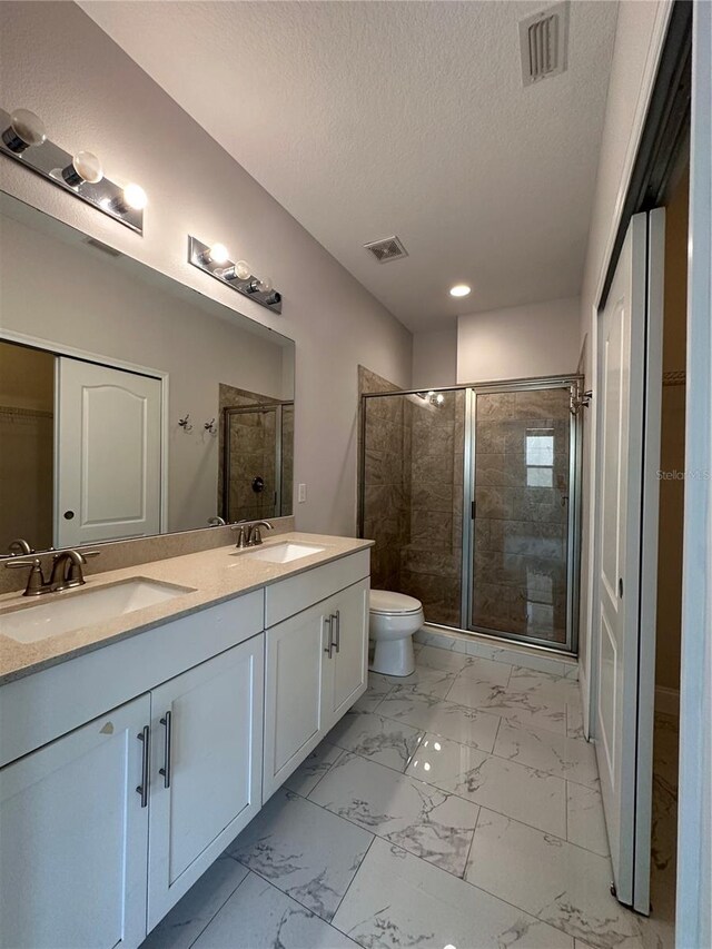 bathroom with vanity, an enclosed shower, a textured ceiling, and toilet